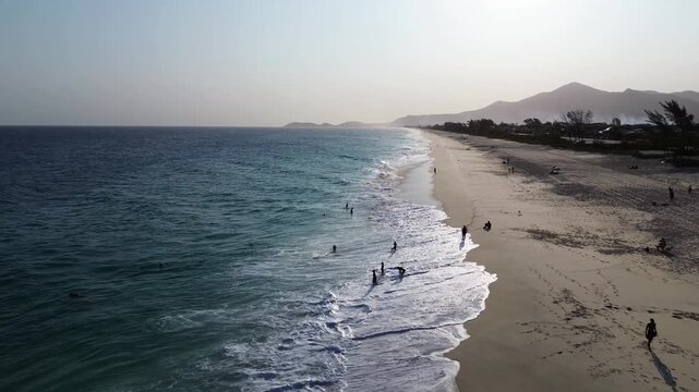 Uncrowded sandy beach and tropical sea. Mountains in the background - Saquarema, Brazil