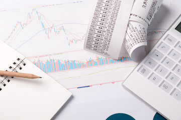 Fototapeta premium Calculator and receipts on financial charts for budgeting and expense analysis