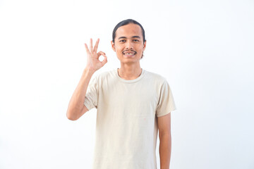 Young Asian man in a shirt, give OK or approved sign expression. Isolated in white background