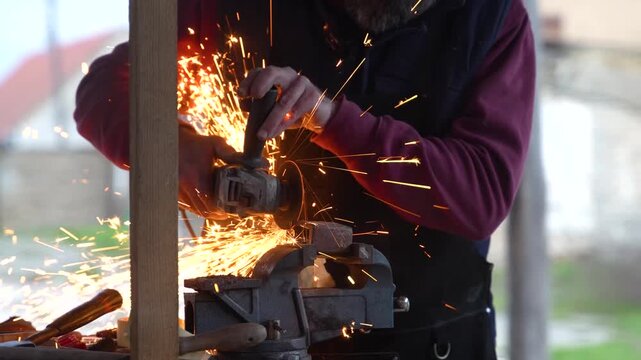 Industrial Worker Using Angle Grinder With Flying Sparks