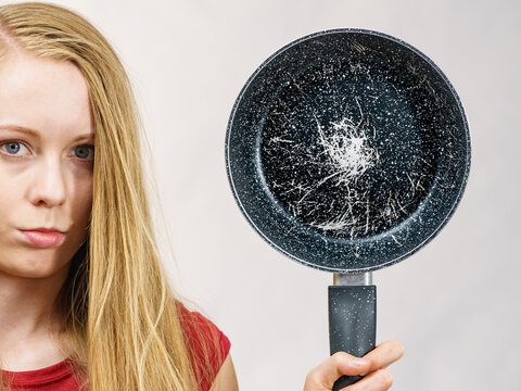 Girl holding scratched frying pan