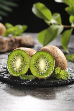 Fresh Kiwi Fruit Slices with Green Flesh and Seeds on Slate Board