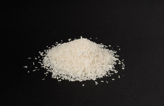 Grated coconut powder. Dry coco flakes pile, shredded desiccated coconut, tropical fruit chips