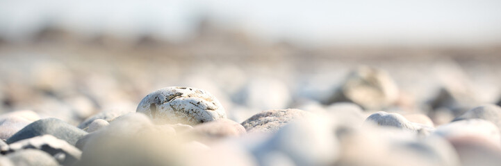 Minimal beach stones in soft sand with shallow depth of field © Lumae Nord