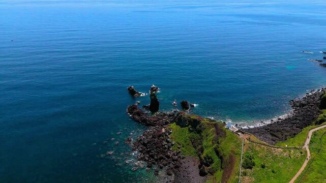 Aerial view of sea stack rocks and white lighthouse at Seopjikoji cape, Jeju Island, South Korea