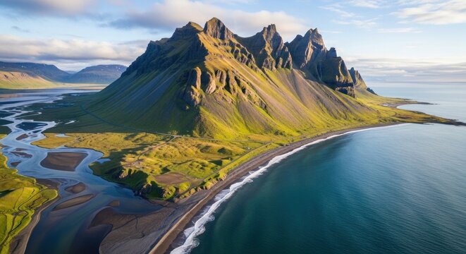 Aerial view of rugged stok mountain range with river delta and ocean waves
