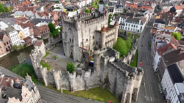 Aerial drone view of Ghent old town in Belgium, with the towers of St. Nicholas and St. Michael's Churches and Castle of the Counts next to river Lys. Architecture and landmarks of the medieval city.