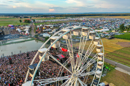Herzogenaurach, Germany - 24 July 2025: Aerial view of Open Beatz Festival featuring a large white ferris wheel, a dense crowd of people, and various stages across the festival grounds.