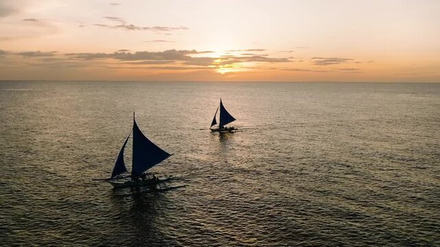 Sailboats at sunset. Beautiful cloudy sunset over the sea. Boracay, Philippines.