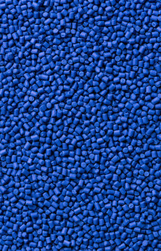 Large group of high-quality blue plastic pellets and raw polymer granules used as resin feedstock for industrial manufacturing, injection molding, and production of synthetic materials like polyeth...