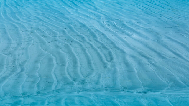 Summer background lagoon Ripples in the sand at low tide on a beach with sandbar and blue sea in Maldives island