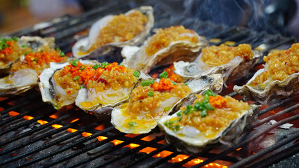 Fototapeta premium Grilled Oysters with Garlic at Night Food Market