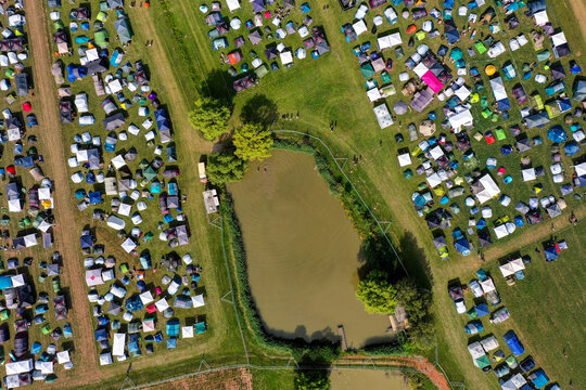 Herzogenaurach, Germany - 24 July 2025: Aerial view of the Open Beatz Festival campsite with numerous colorful tents pitched on green fields during a sunny day.