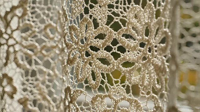 Closeup of intricate handmade lace fabric with floral patterns.
