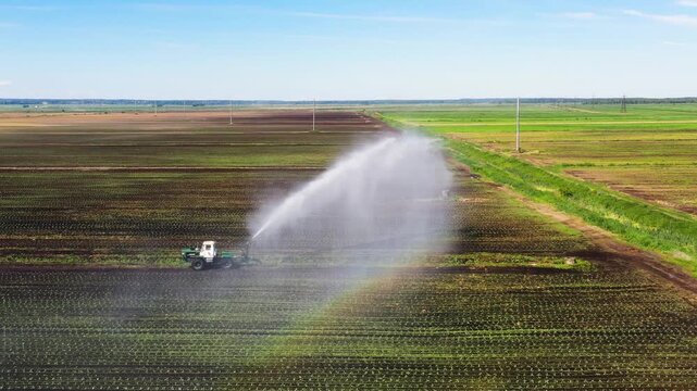 Irrigation of farmland with a tractor irrigation system from above. An irrigation pivot watering agricultural land. Irrigation system watering farm land.