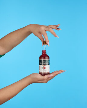 Female hands holding a natural cosmetic serum bottle with pipette for skincare advertising