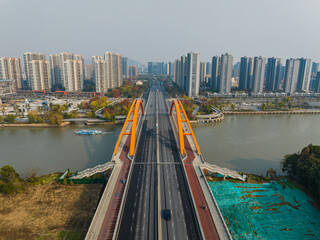 Aerial View of Orange Arch Bridge Over Urban River © ThaiKhanh