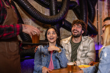 Fototapeta premium Diverse friends drinking beer in industrial style pub