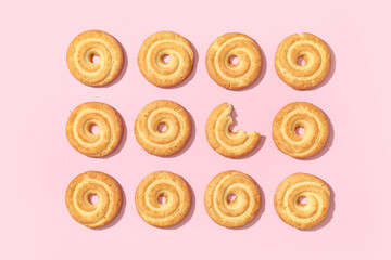 Fototapeta premium Many tasty spritz biscuits on pink background, top view