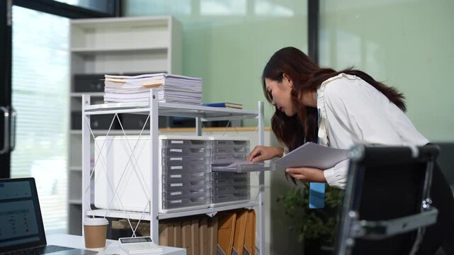 Businesswoman searching through of business documents. Concept of office work, report analysis, and document organization.