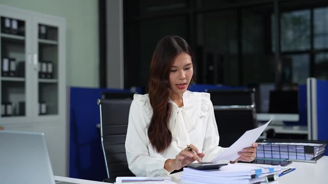 Business woman calculates financials with graph paper on the table on the cost.