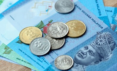 Malaysian ringgit money bills and coins on table. Malaysia cash of MYR currency close up © Larysa