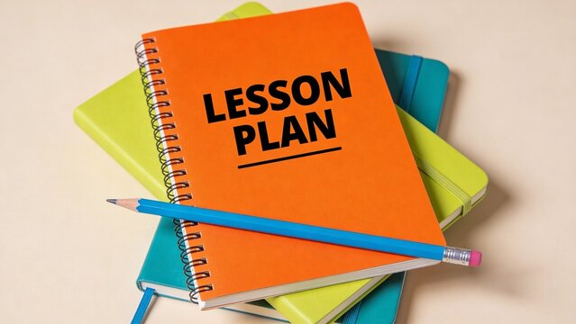 A stack of colorful notebooks and a pencil on a table with a lesson plan notebook on top
