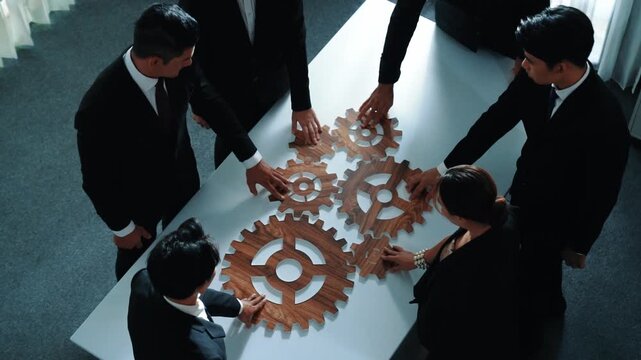 Top view of smart business people gather wooden cog together at meeting. Group of project manager helping and team working to solve problem at meeting room or workplace. Represent unity. Directorate.