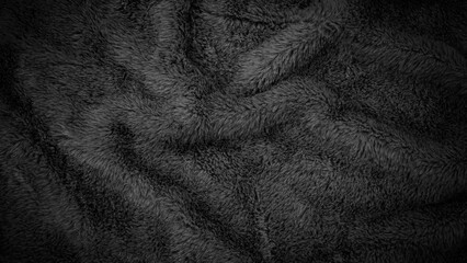 Soft black fabric with wave patterns used for warmth during cold nights in a cozy room setting © Fleuronica