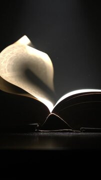 Super Slow Motion Quiet Scene Capturing Slowmoving Pages Of Book With Dramatic Lighting And Silhouette Effect