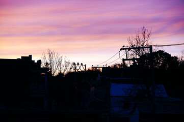 Pylônes et fils électriques dans la lumière du soir au coucher du soleil en ville.  © Pascal Huot