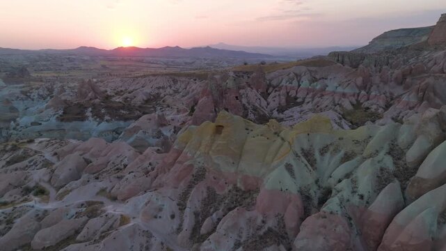 Goreme, Nevsehir, Turkey. Red Valley multicolored rock formations, red white and yellow mineral strata layers, aerial view at sunset over eroded volcanic tuff landscape. Aerial View