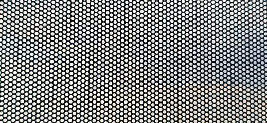 An enlarged image of a see-through sticker, which has small perforations throughout the sheet. One Way Vision, thick PVC material with small perforations. Similar to perforated metal plate.  © Vanchuree