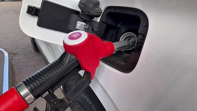 Video of a car being refueled. A nozzle is inserted into the car's gas tank.