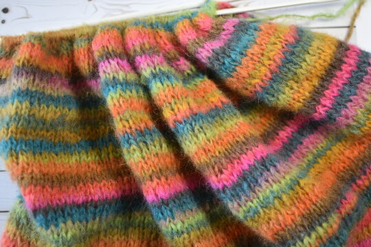 pice of hand knitting on knitting needles colourful stripes 