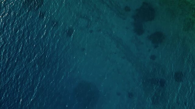 Zadar, Croatia - 05 17 2025: Top-down drone video of the Adriatic Sea in Zadar, showing deep blue and teal water with gentle ripples and shimmering highlights, conveying vastness at sunset.
