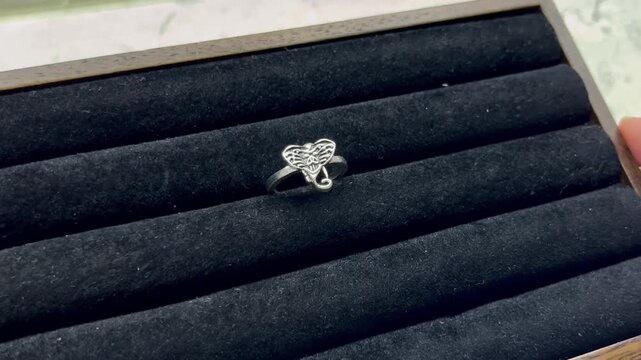 Presented on a black velvet stand, this sterling silver elephant head ring showcases intricate design details and a smooth surface, highlighting the elegant craftsmanship and texture of the jewelry.