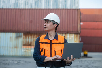 Fototapeta premium Logistics manager using laptop at container yard