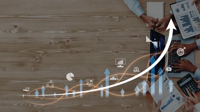 A top-down view of a professional team analyzing data charts and discussing business growth strategies, featuring upward arrows and graphs on a wooden table. Raster