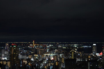Obraz premium Breathtaking night view of Kobe city skyline and port illuminating under the dark twilight sky, Hyogo, Japan