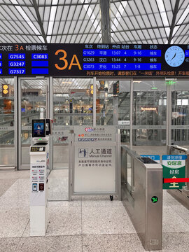 Shanghai railway station, China, 3 April 2026 - Gate 3A departure hall with automated ticket barriers, manual channel booth, and digital train schedule board showing high-speed rail departures.