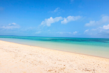 Obraz premium 沖縄県竹富島の美しい白い砂浜と透き通るエメラルドグリーンの海 Beautiful white sand beach and crystal clear emerald green ocean in Taketomi Island, Okinawa