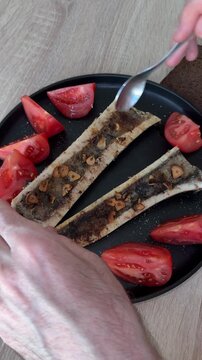 Roasted bone marrow served with fresh tomatoes during dining experience, representing gourmet cuisine, traditional food culture and premium culinary dish