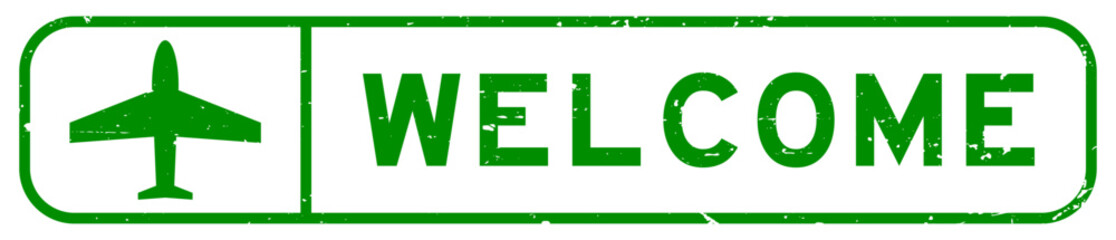 Grunge green welcome word with plane icon square rubber seal stamp on white background © bankrx