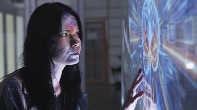 Businesswoman touches a glowing blue holographic brain diagram on a transparent screen, symbolizing AI, neuroscience, or digital intelligence technologies.