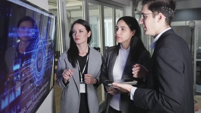 Three professionals in a business meeting setting with laptops, focused on a screen showing an AI-themed digital brain graphic and code.