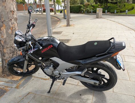 Vista lateral de moto Yamaha YBR 250 Naked con nombre Adelita estacionada en Madrid, Espa&ntilde;a, 9 de abril de 2026
