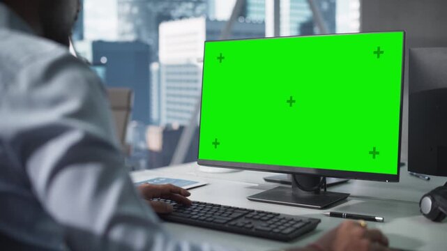 Businessman Using Green Screen Monitor in Modern Office