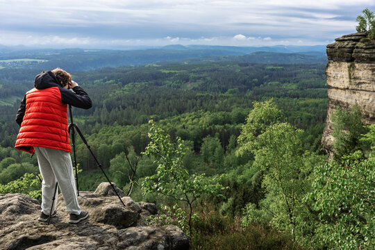 Teenager photographing landscape from Grosser Zschirnstein, Saxon Switzerland, Germany.