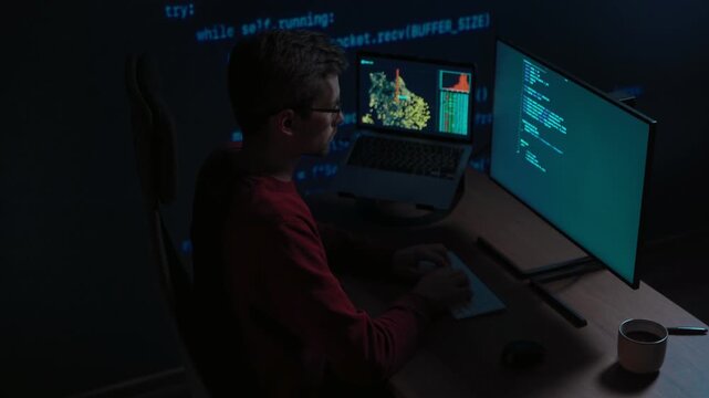 Software engineer writing script at his desk with laptop displaying data science graph with code projected behind. Developer works late on a machine learning or AI project. Space for text